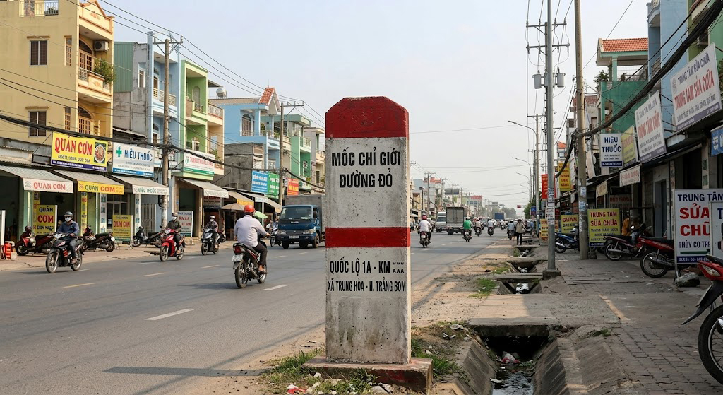Biển cắm mốc chỉ giới đường đỏ bê tông tại mặt tiền Quốc lộ 1A đoạn qua xã Trung Hòa huyện Trảng Bom Đồng Nai, nhà dân hai bên đường mật độ cao
