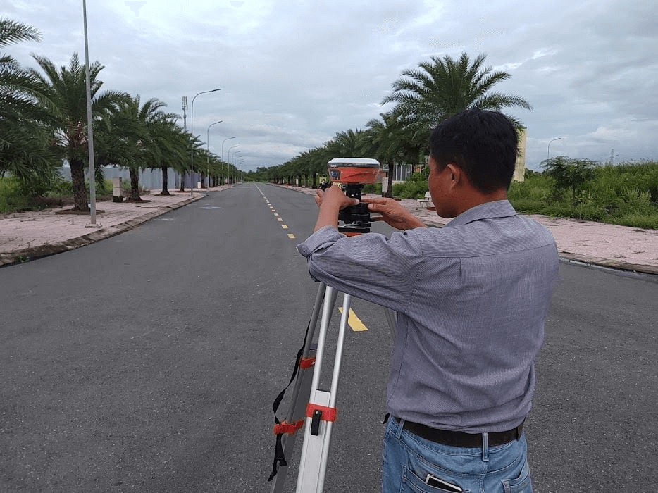 Kỹ sư trắc địa sử dụng máy GPS RTK đang đo đạc xác định ranh giới thửa đất tiếp giáp chỉ giới đường đỏ mới trên trục đường Nguyễn Ái Quốc đoạn phường Hóa An thành phố Biên Hòa Đồng Nai