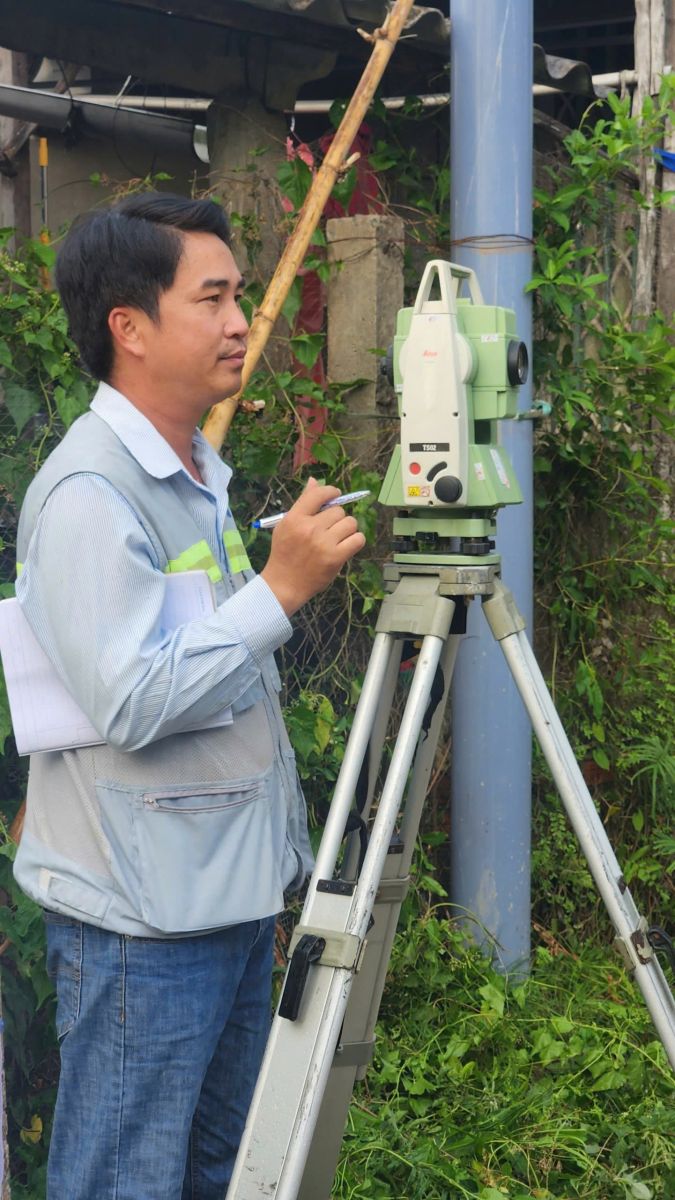 Hình ảnh kỹ sư Đo Đạc Đồng Nai đang đặt mốc ranh giới bê tông tại góc thửa đất hẻm nhỏ khu vực phường Quang Vinh Biên Hòa, xung quanh là nhà dân xây sát nhau dày đặc